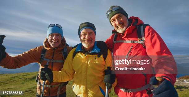 smiling friends standing against sky - holding sunglasses stock pictures, royalty-free photos & images