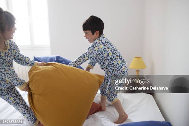 a brother and a sister having a pillow battle - fighting game stock pictures, royalty-free photos & images