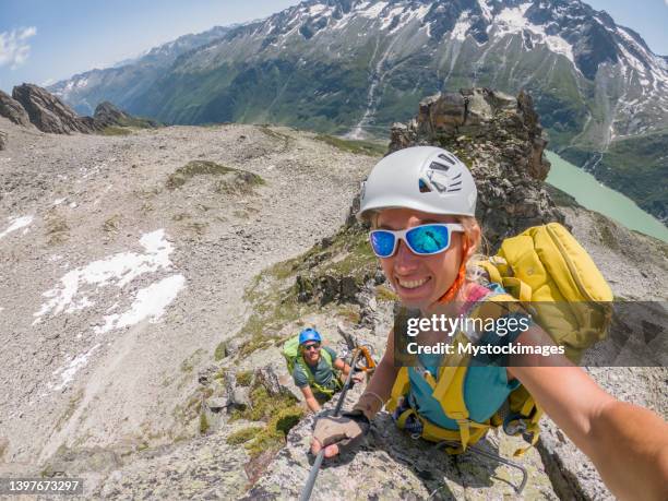 paar, das beim klettern ein selfie auf dem klettersteig macht, im sommer outdoor-sportaktivität - gopro stock-fotos und bilder