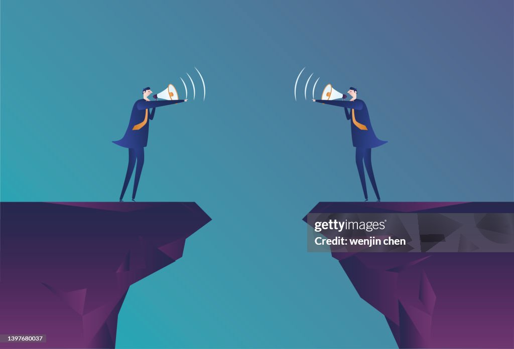 Two business men are arguing with a megaphone while standing on a cliff.