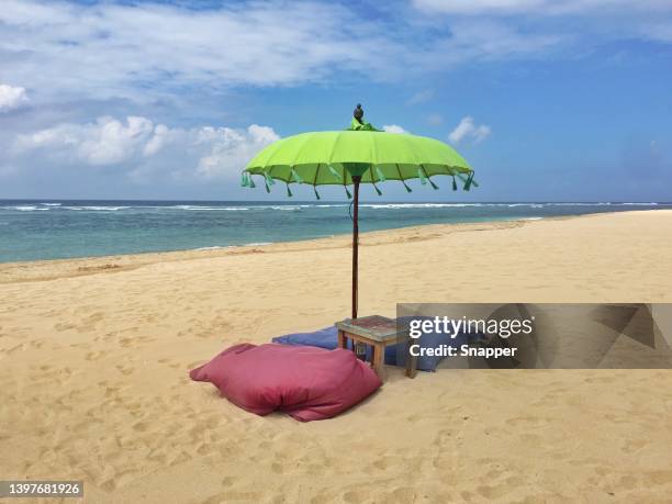 parasol and cushions on tropical beach, nusa dua, bali, indonesia - nusa dua stock pictures, royalty-free photos & images