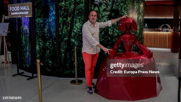 The artist Felipao poses with one of his works, a polyhedral sculpture in the shape of a menina, in the Exhibition: Gastroart by Felipao in the Food...