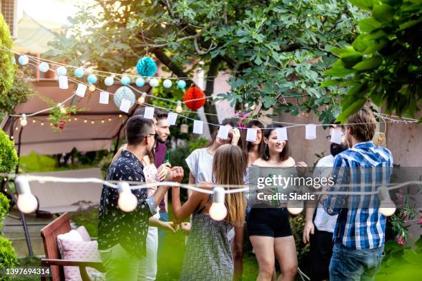 gruppe von hübschen jungen leuten haben ein sommerfest in einem hinterhof - gartenfest stock-fotos und bilder