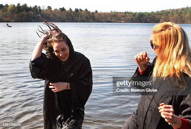 Rachel Goldstein, left, of Michigan, emerges from the waters of Lake Waban after winning the 113th annual hoop rolling contest at Wellesley College...