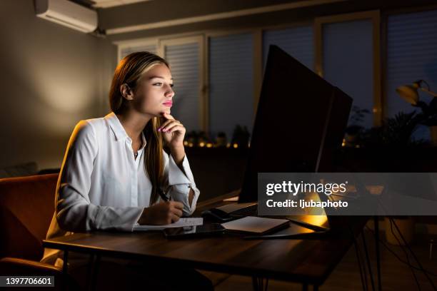 woman working from home, handwriting a document. - staring at screen stock pictures, royalty-free photos & images