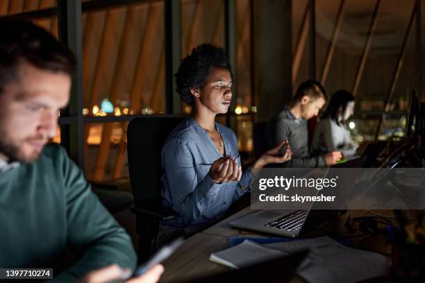 meditating during late work in the office! - overtime sport stock pictures, royalty-free photos & images