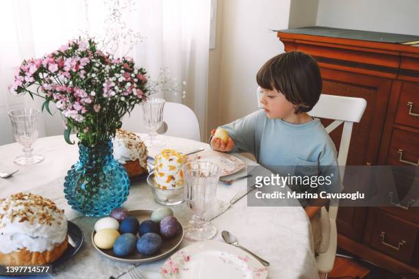 child helping setting easter table. - orthodox easter 個照片及圖片檔