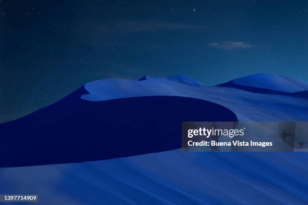 sand dunes in a desert at night - namibia sternenhimmel stock-fotos und bilder
