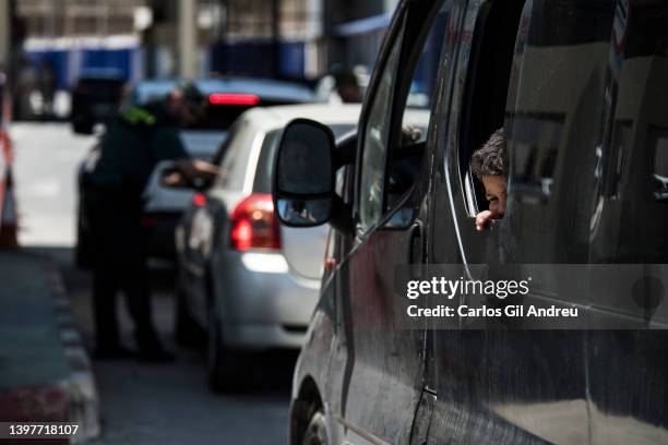 Child looks out the car window as they queue to cross the international border from El Tarajal into Morocco on May 17, 2022 in Ceuta, Spain. The...