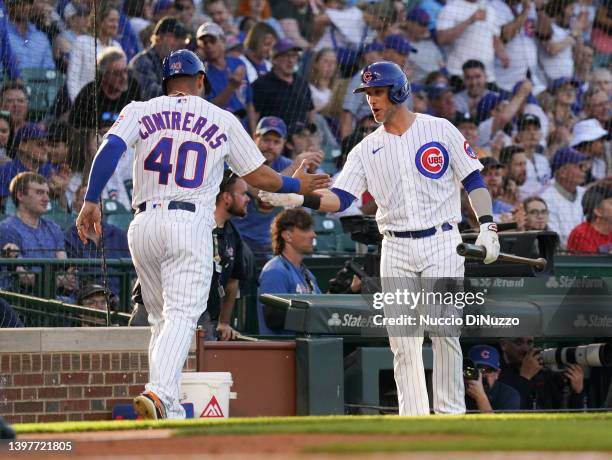 Willson Contreras of the Chicago Cubs is congratulated by Yan Gomes of the Chicago Cubs after scoring during a game against the Pittsburgh Pirates at...