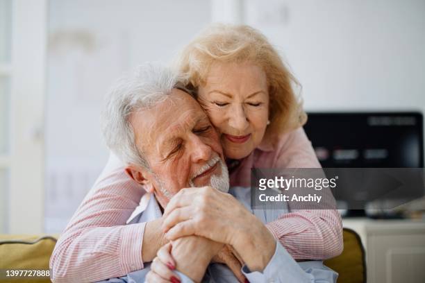 portrait of a happy senior couple - white sofa stock pictures, royalty-free photos & images