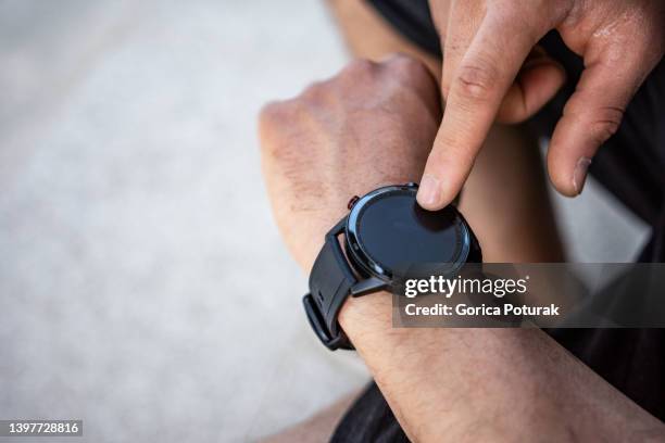 mann, der den fortschritt nach dem training auf dem smartphone überprüft. nahaufnahme - mens wrist watch stock-fotos und bilder
