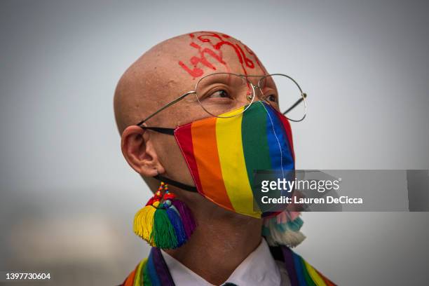 Sirisak “Ton” Chaited, a human rights activist for equality, wears a rainbow mask during a rally in recognition of the International Day Against...