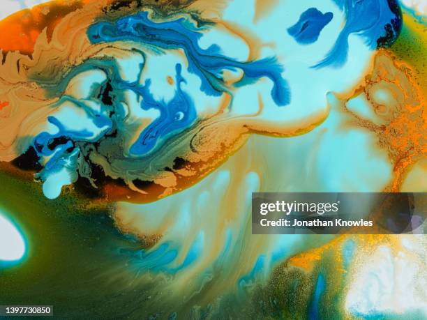 orange, blue and green oils mixing - mixing stock pictures, royalty-free photos & images