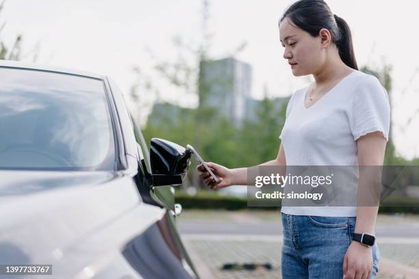 asian young woman is using smartphone to unlock car - car nfc stock pictures, royalty-free photos & images