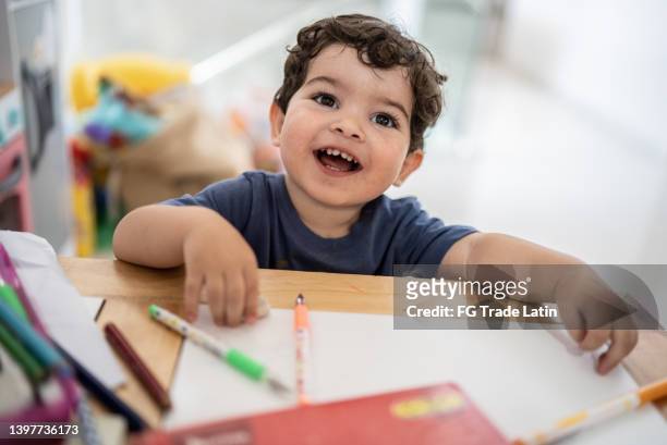 portrait of little boy studying - babyhood bildbanksfoton och bilder