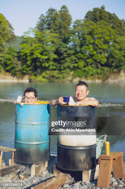 oil barrel bathing fun by the river - sauna ストックフォトと画像