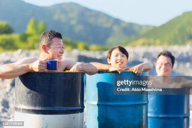 bathing in oil barrels by the river - komische sketches stockfoto's en -beelden