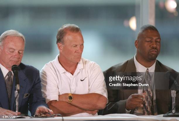 Defensive end Charles Haley and coach Barry Switzer of the Dallas Cowboys listen to owner Jerry Jones during a press conference annoucing Haley''s...