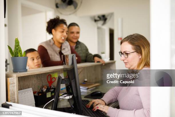 family checking appointment details with the secretary - screening of netflixs to all the boys ive loved before arrivals stockfoto's en -beelden