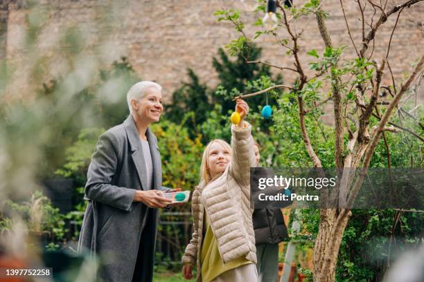 bunte ostereier im garten - frohe ostern stock-fotos und bilder