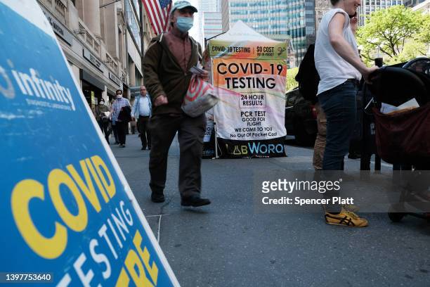 People walk past a Covid testing site on May 17, 2022 in New York City. New York’s health commissioner, Dr. Ashwin Vasan, has moved from a "medium"...