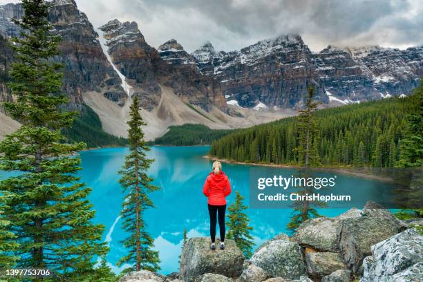 female hiker stood looking over lake moraine, banff national park, canada - moraine lake stock pictures, royalty-free photos & images