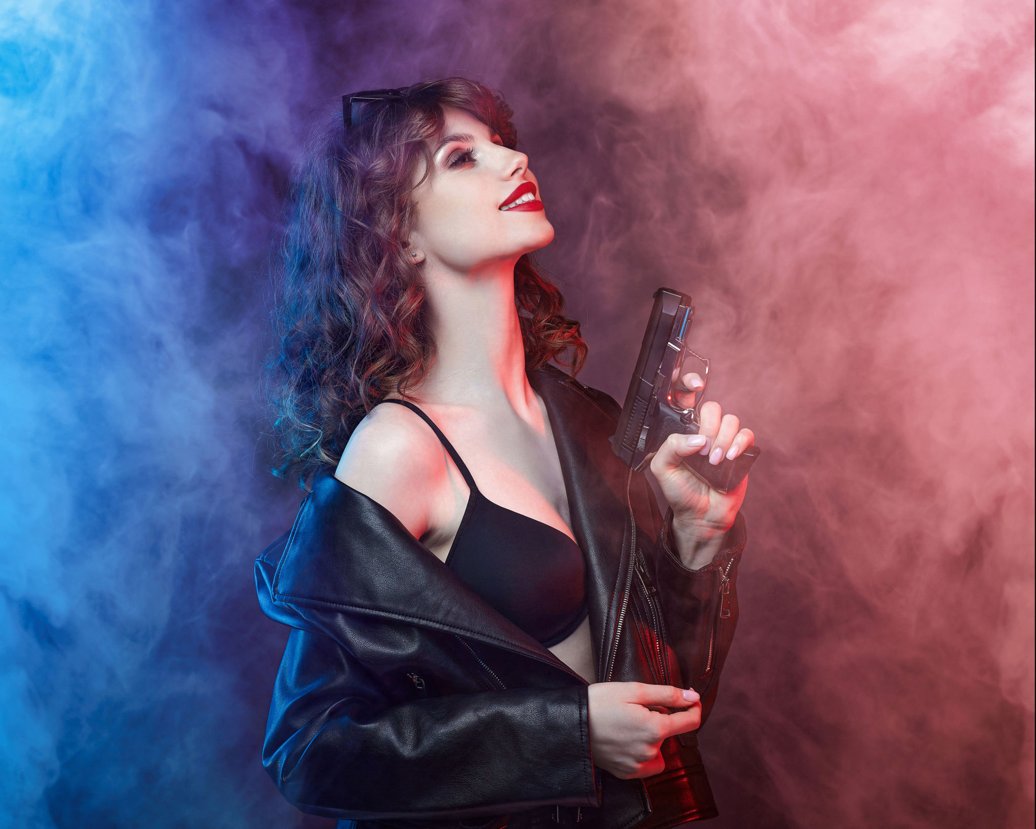 beautiful young Caucasian girl with bright red lips poses with a gun. beautiful young Caucasian girl with bright red lips poses with a gun.