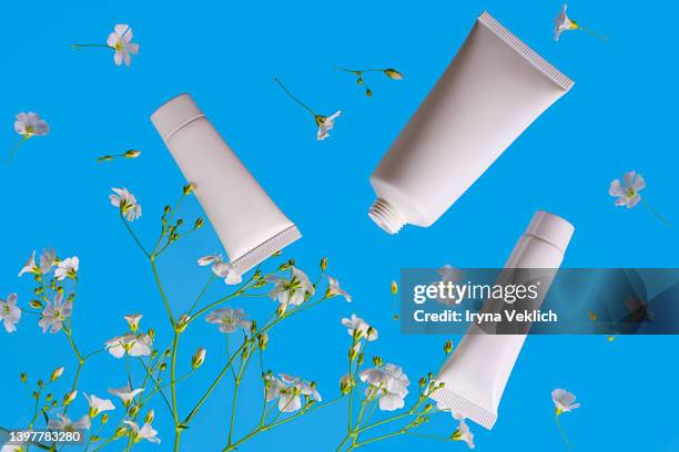 natural organic cosmetics beauty products  face cream, moisturizing hand cream in tube and white flowers. - creme tube ストックフォトと画像