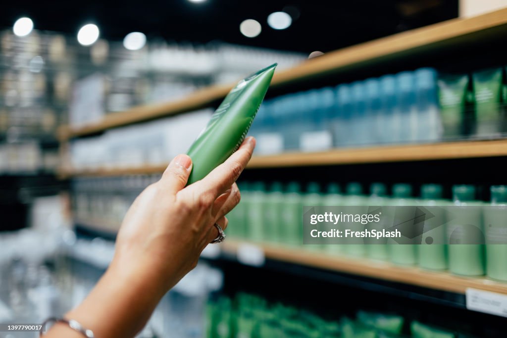 A Close Up View Of An Unrecognizable Female's Hand Holding Some Beauty Product