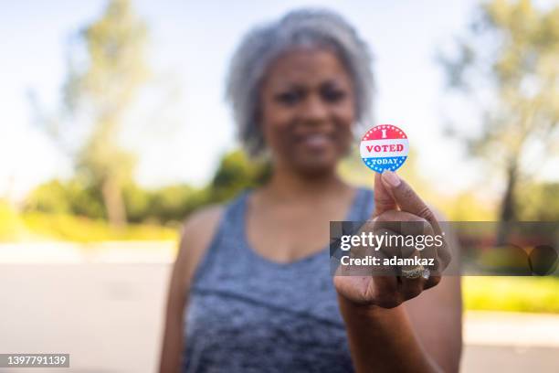 mujer negra mayor con pegatina de i vote - voter fotografías e imágenes de stock