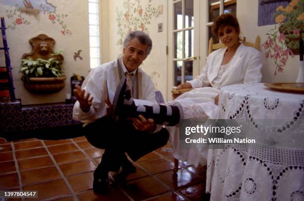 American actor and television host Jed Allan helps his wife Toby at their home circa July, 1991 in Los Angeles, California.