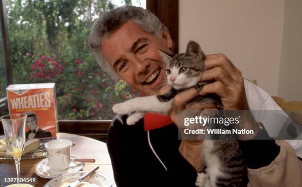 American actor and television host Jed Allan , poses for a portrait with his cat at home circa July, 1991 in Los Angeles, California.