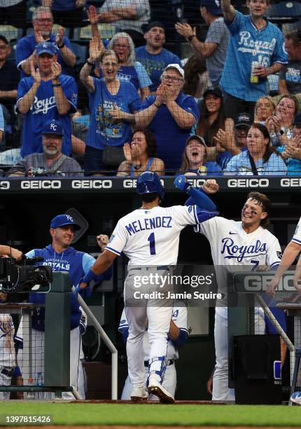 Melendez of the Kansas City Royals is congratulated by Bobby Witt Jr. #7 and teammates in the dugout after hitting his first Major League home run...