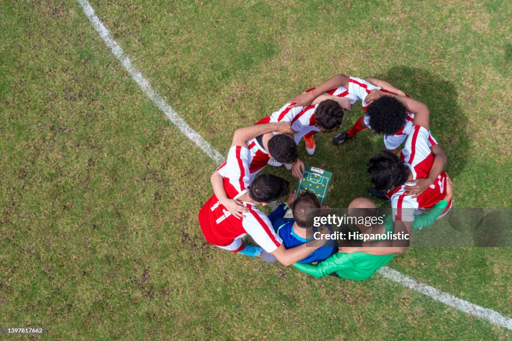 Entrenador hablando con un equipo de futbolistas sobre su estrategia para el juego