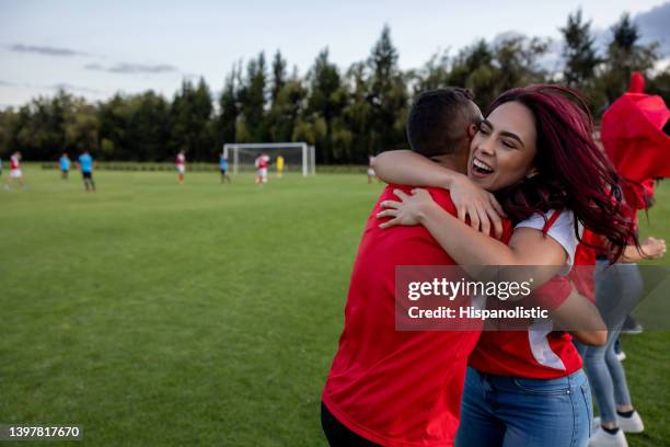 appassionato di sport felice che festeggia un gol con un calciatore - side lines foto e immagini stock