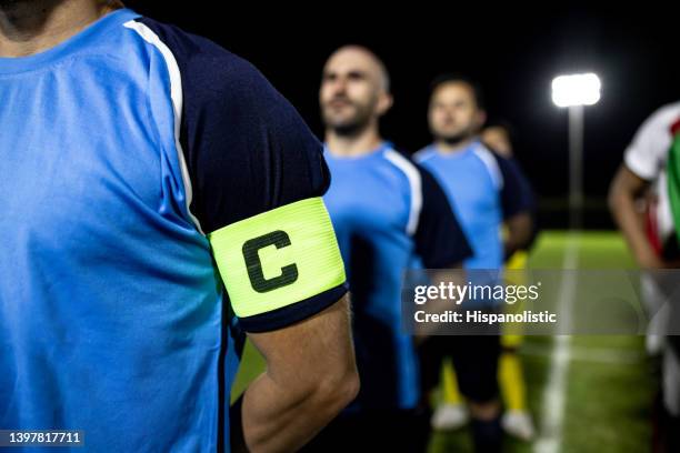 close-up on a captain band on the arm of a soccer player - skipper stockfoto's en -beelden