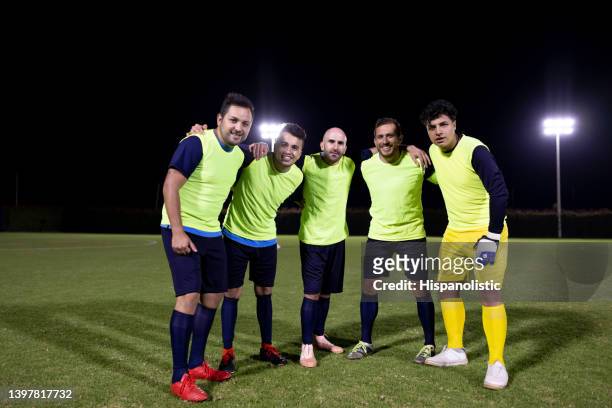 team of soccer players at practice hugging and smiling at the camera - pinafore dress stock pictures, royalty-free photos & images