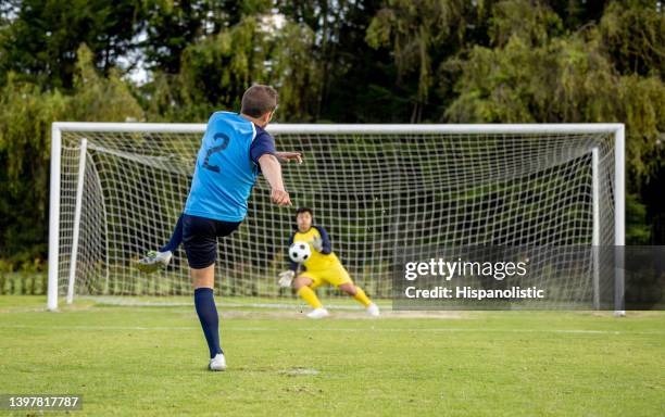 soccer player taking a penalty kick while playing a game - penalty kick stock pictures, royalty-free photos & images