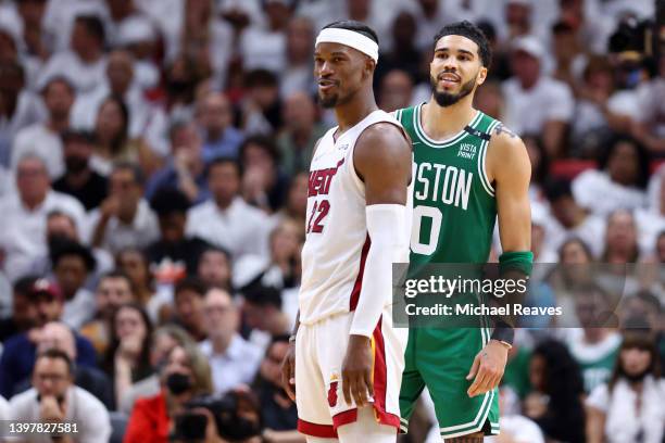 Jimmy Butler of the Miami Heat and Jayson Tatum of the Boston Celtics look on during the fourth quarter in Game One of the 2022 NBA Playoffs Eastern...