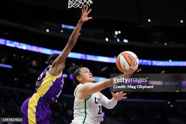Guard Kayla McBride of the Minnesota Lynx puts up a shot and scores and is fouled by guard Brittney Sykes of the Los Angeles Sparks with two seconds...