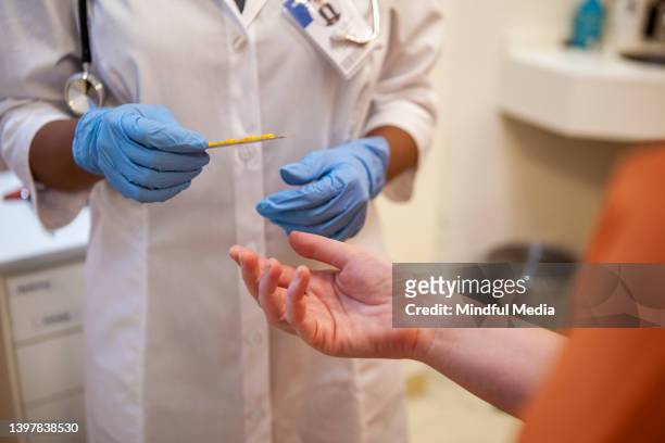 close up shot of healthcare worker's gloved hands holding blister pack of medication - prison imagens e fotografias de stock