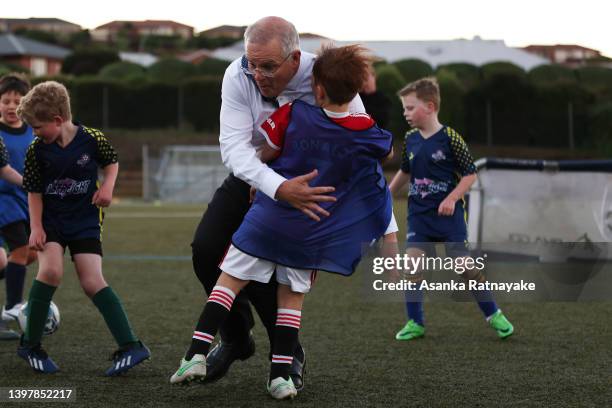 Prime Minister Scott Morrison accidentally knocks over a child during a visit to the Devonport Strikers Soccer Club, which is in the electorate of...