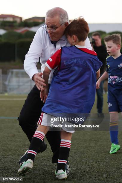 Prime Minister Scott Morrison accidentally knocks over a child during a visit to the Devonport Strikers Soccer Club, which is in the electorate of...