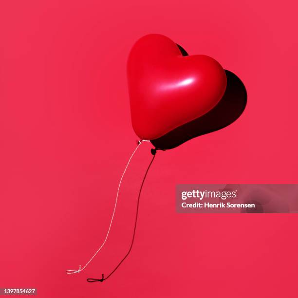 red balloon levitated - heart balloon stock pictures, royalty-free photos & images