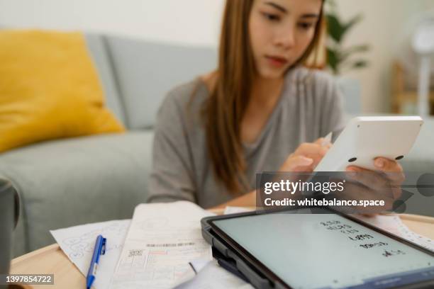 woman analyzing documents while sitting at home. - tuition stock pictures, royalty-free photos & images