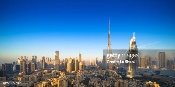 high angle view of modern city skyline and cityscape at sunrise in dubai uae. - burj khalifa stock-fotos und bilder