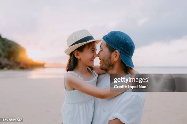 father and young daughter rubbing noses on beach at sunset - rubbing noses stock pictures, royalty-free photos & images