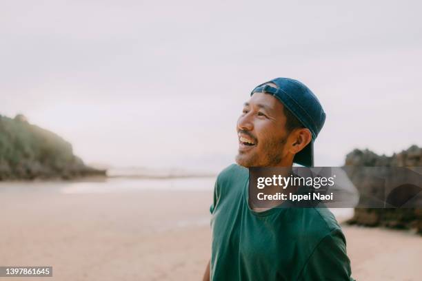 man laughing on beach at dusk - portrait candid ストックフォトと画像