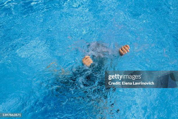 the child is drowning in the pool. drowning man. dangerous swimming. save a person. - ertrinken stock-fotos und bilder